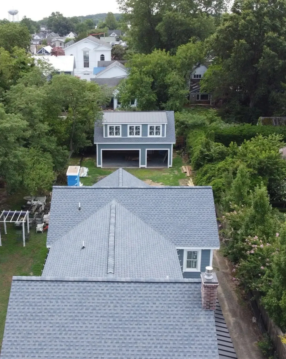 Aerial view of a shingle-roofed home surrounded by trees in Lewes