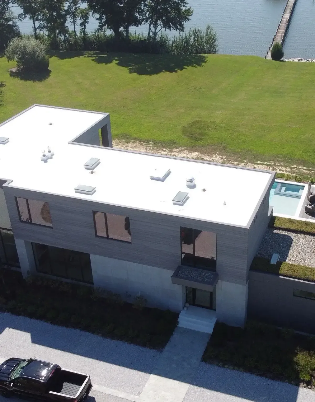 White residential flat roof with multiple roof penetrations