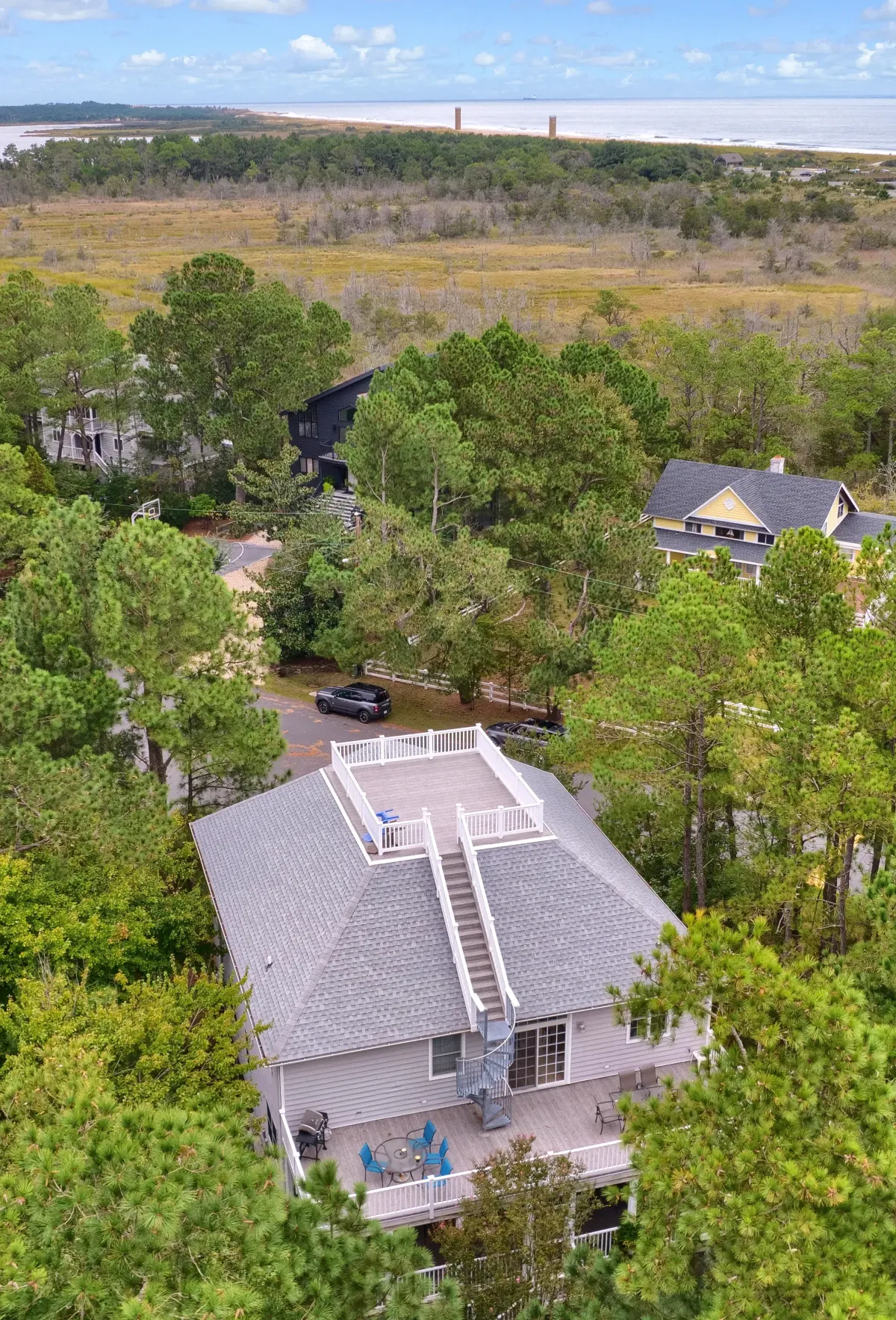 Aerial view of a residential shingle roof surrounded by trees