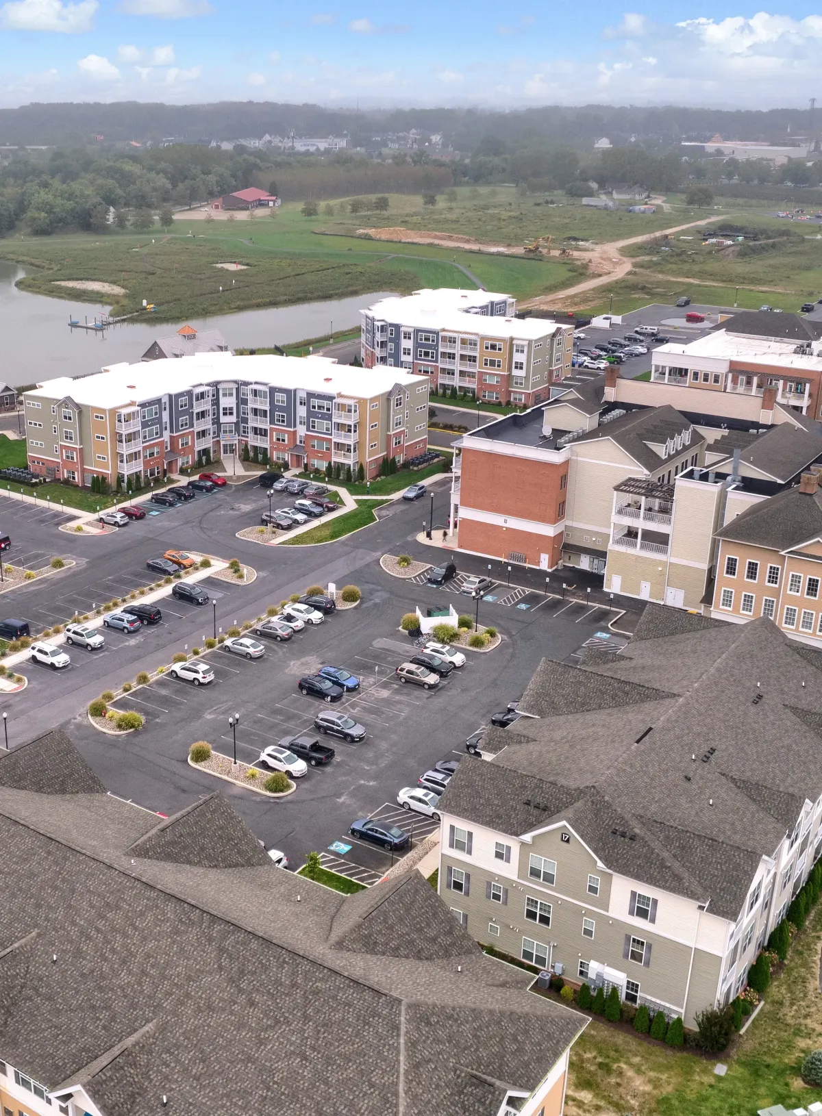 Aerial view of a commercial complex with multiple flat roof sections and parking lots
