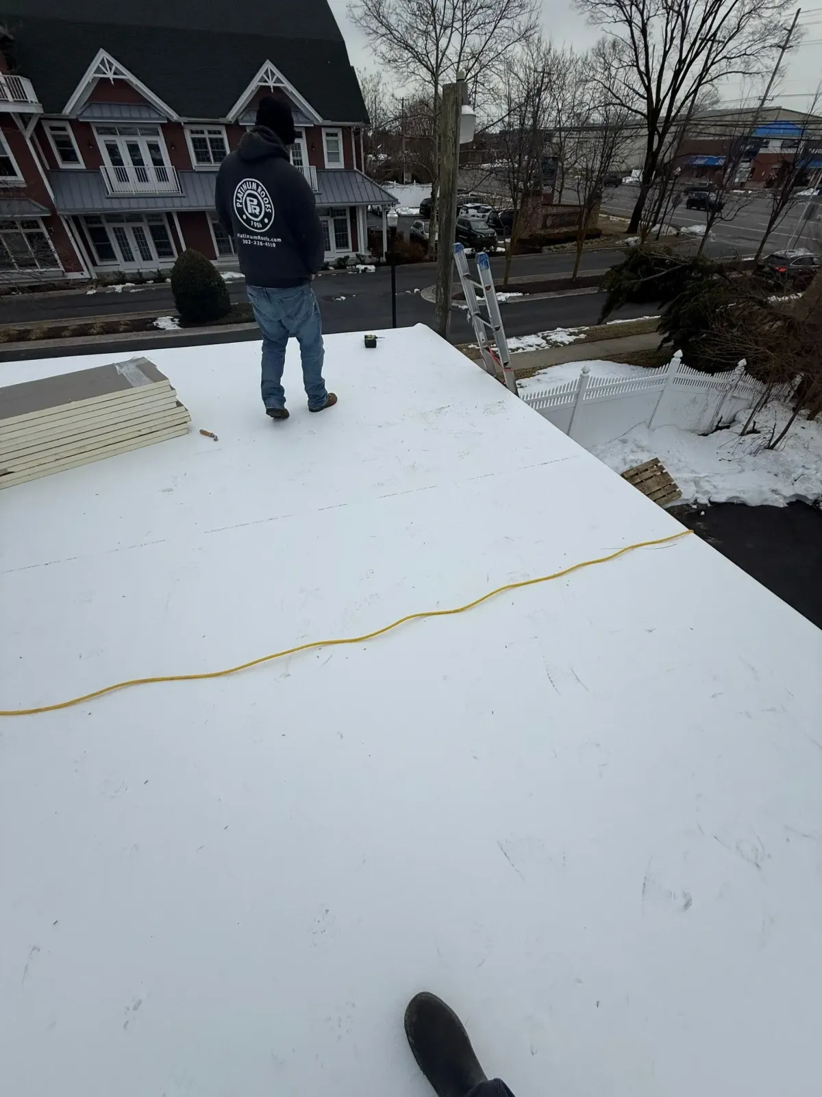 Commercial roof inspection on a snow-covered low-slope roof