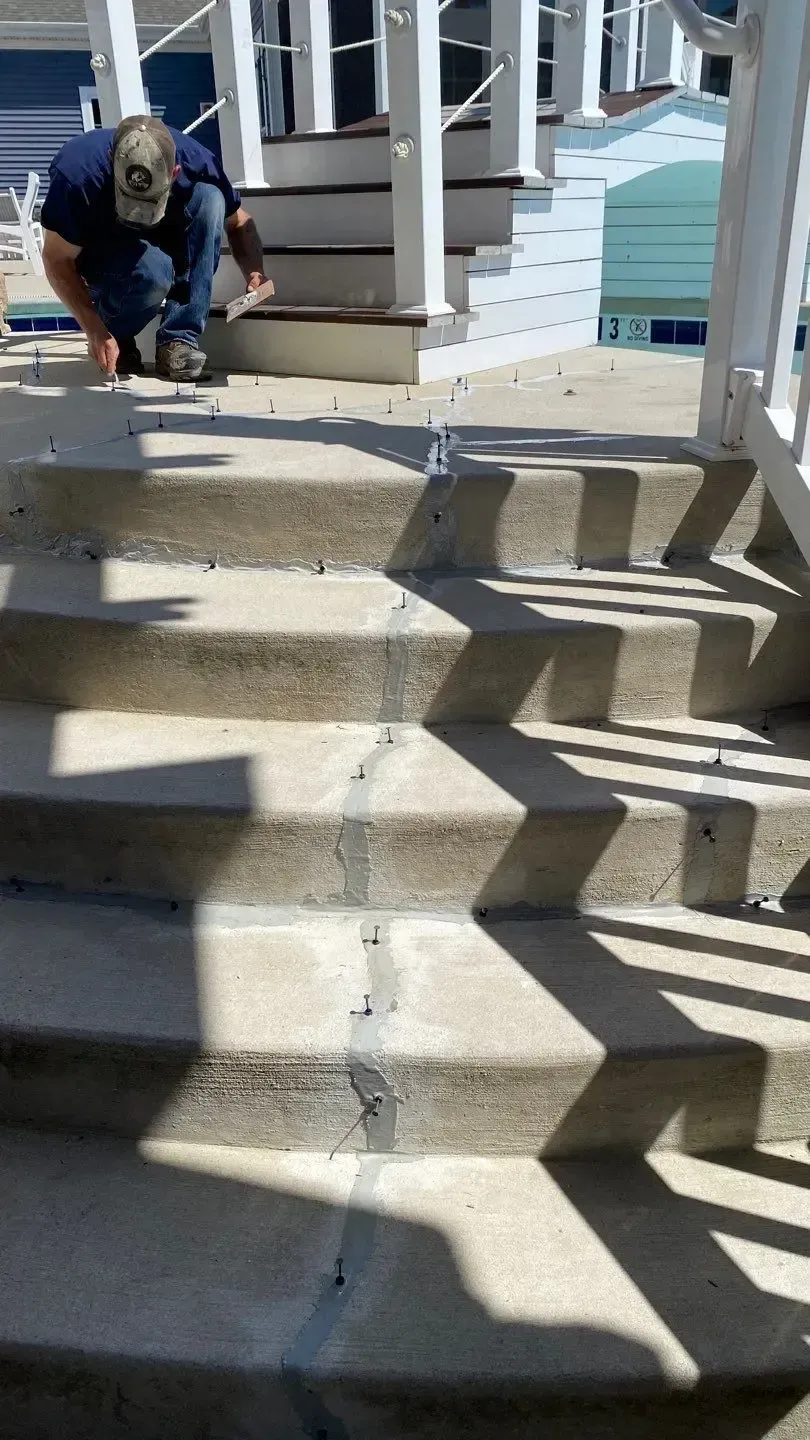 Platinum Roofs team member inspecting a crack running through exterior concrete steps