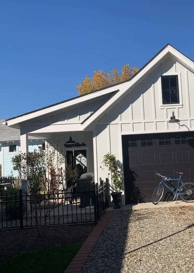 Side view of a coastal home showing the roofline, gutters, and exterior drainage area