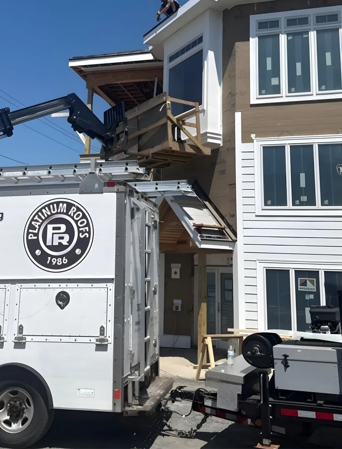 Platinum Roofs crew installing windows on a multi-story coastal home