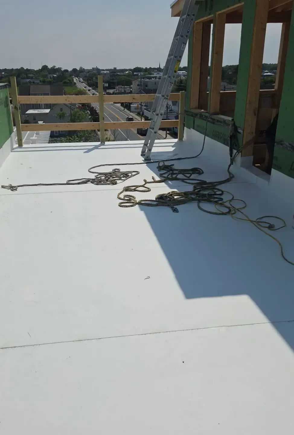 Open roof access door leading onto a flat commercial roof
