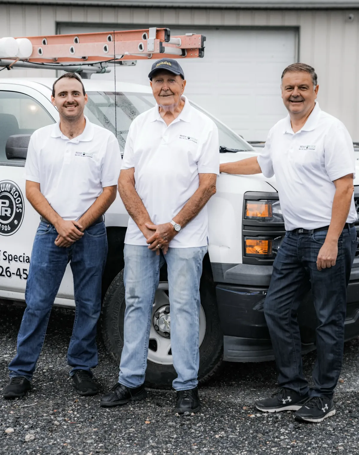 Family owned Platinum Roofs team members standing in front of a branded company truck.