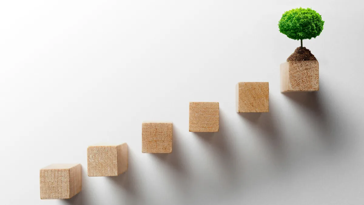 A clean, botanical-themed home office with a laptop, a notebook, and professional myofunctional therapy intake forms on the desk, representing a professional practice setup.