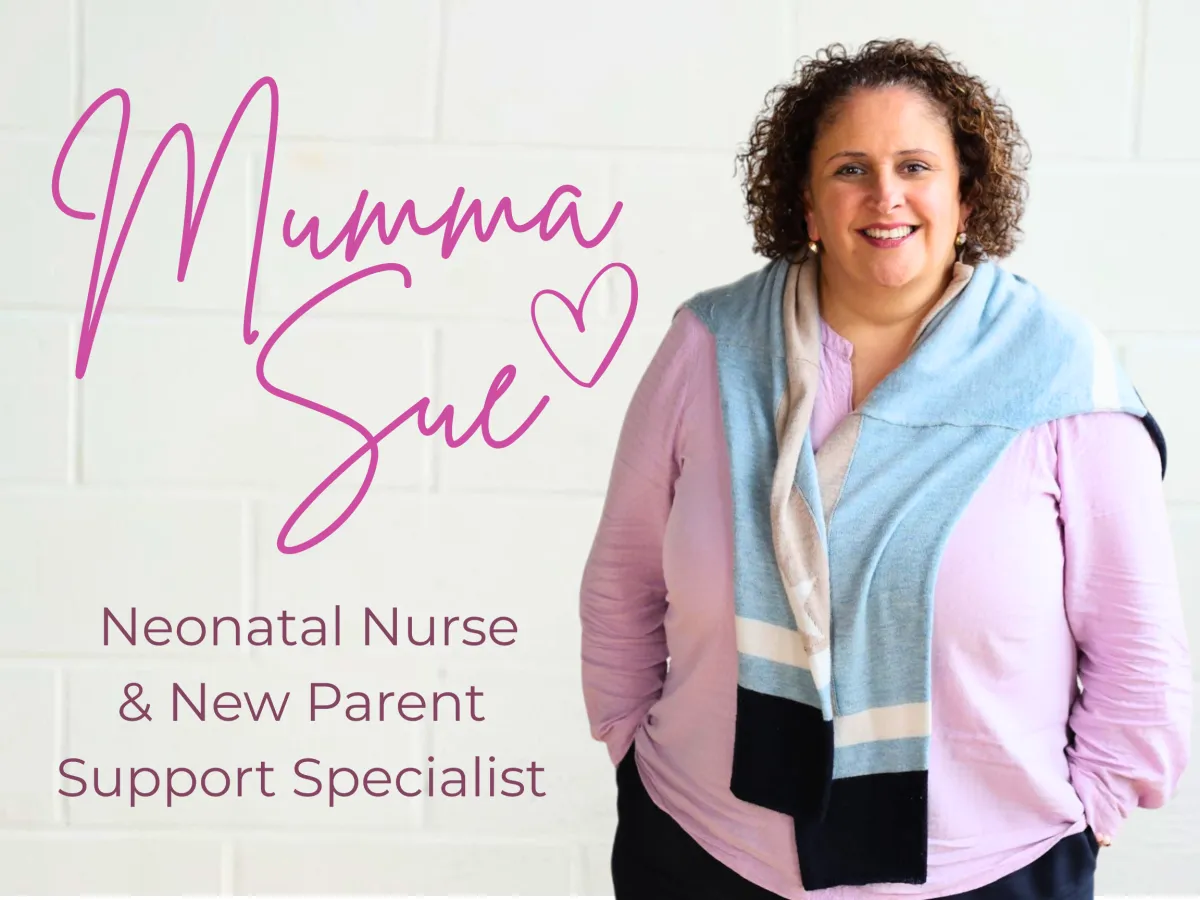 woman in black tank top and black pants sitting on rock near river during daytime