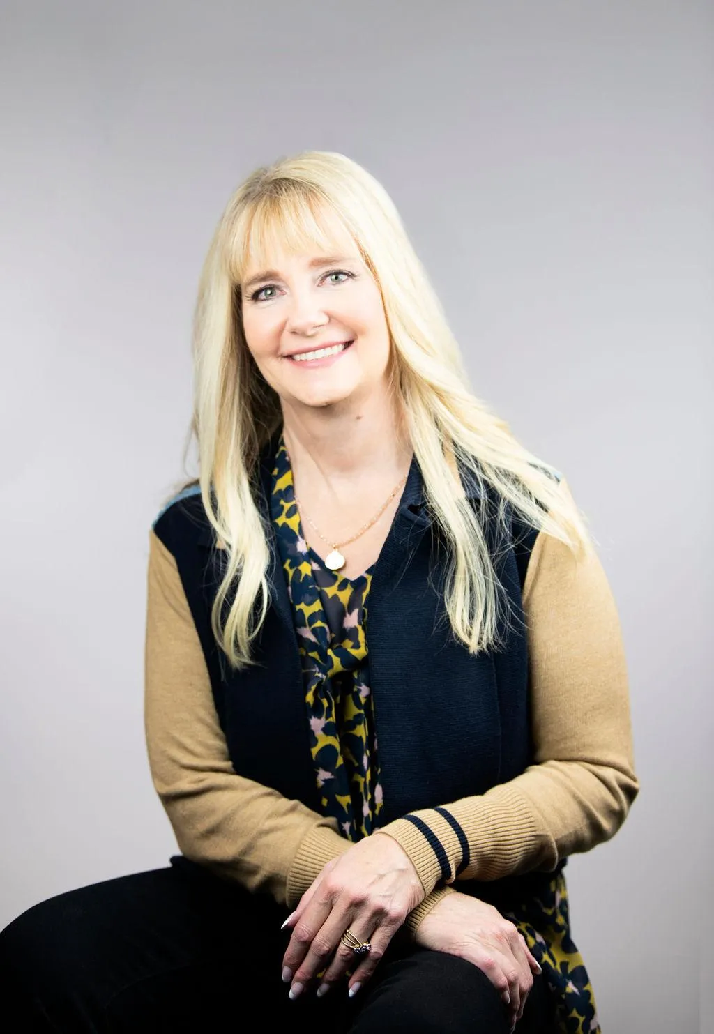 Image of middle aged smiling woman (Deb) with long blonde hair.