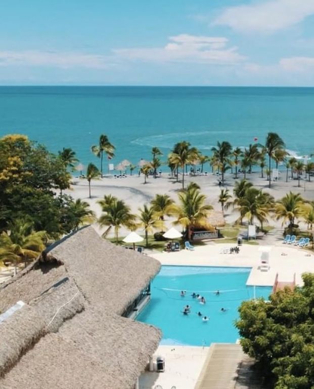 Aerial view of Oceana Resort in Guatemala featuring luxurious swimming pools, sun loungers, and palm trees, highlighting the serene setting for the Passover 2026 program.