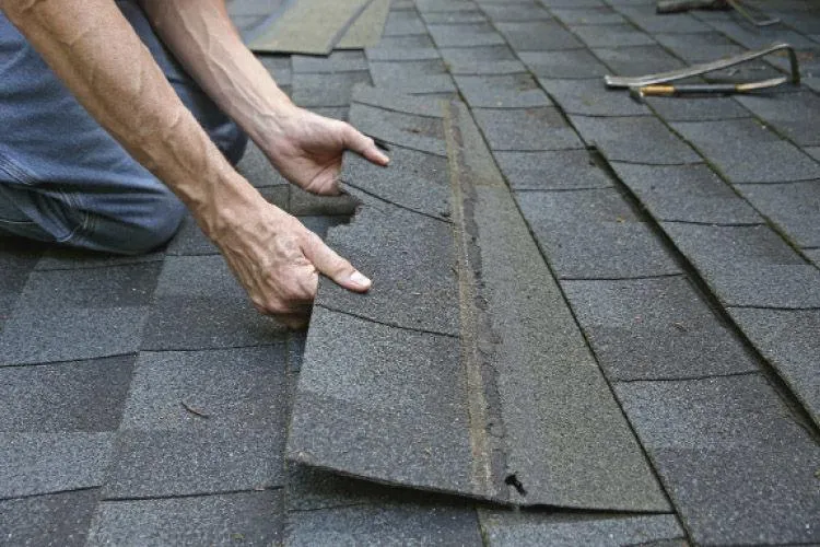 two men working on the roof of a house