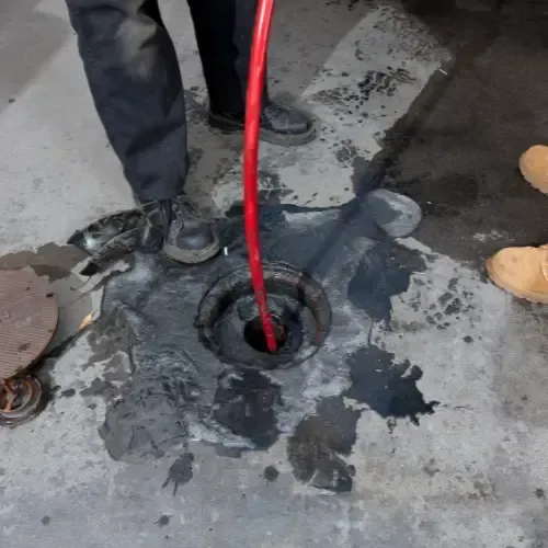 Plumber inserting a vacuum hose into a septic tank for professional cleaning – Eddyson Plumbing offers expert septic tank pumping, maintenance, and wastewater management services.