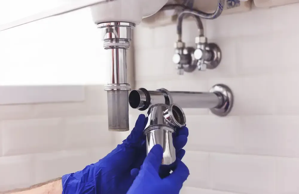 Plumber installing a new sink drain and trap assembly