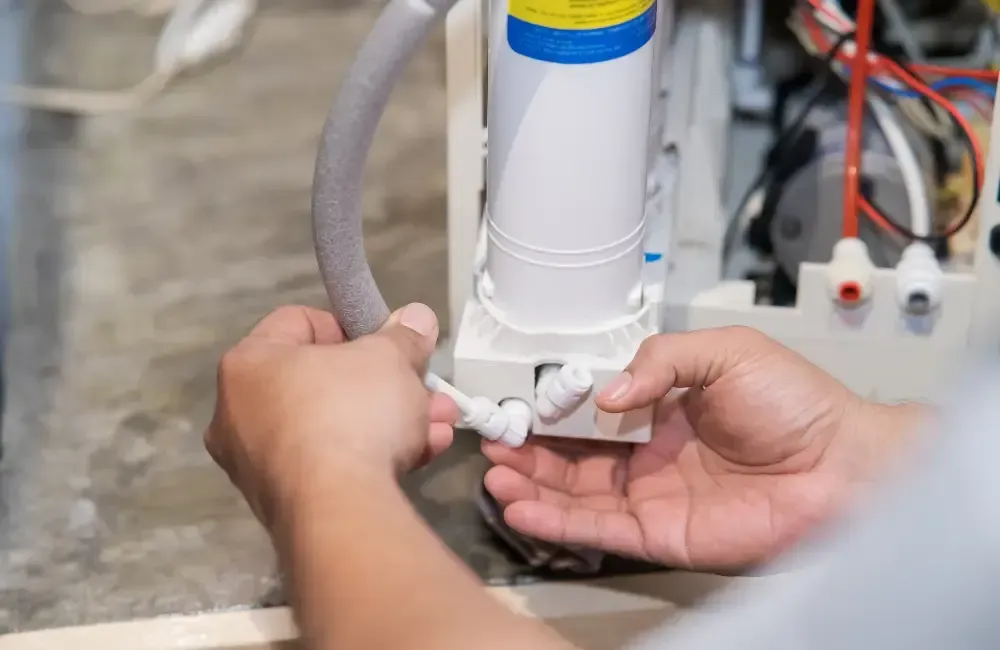 Technician connecting tubing to a water treatment or filtration system