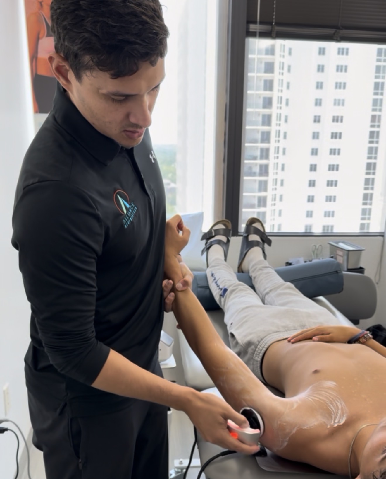 Dr. Dennis, physical therapist at Alliance Regen & Rehab in St. Petersburg performing TECAR Therapy to a patient with shoulder pain.