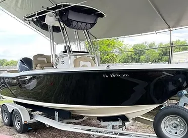 A luxury SUV being detailed in a residential driveway, with a technician using a high-pressure washer, surrounded by lush greenery and sunlight, emphasizing convenience and premium service at home.