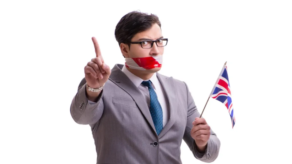 ault man in a business suit with tape coveing his mouth because he's feeling embaassed to spek English
