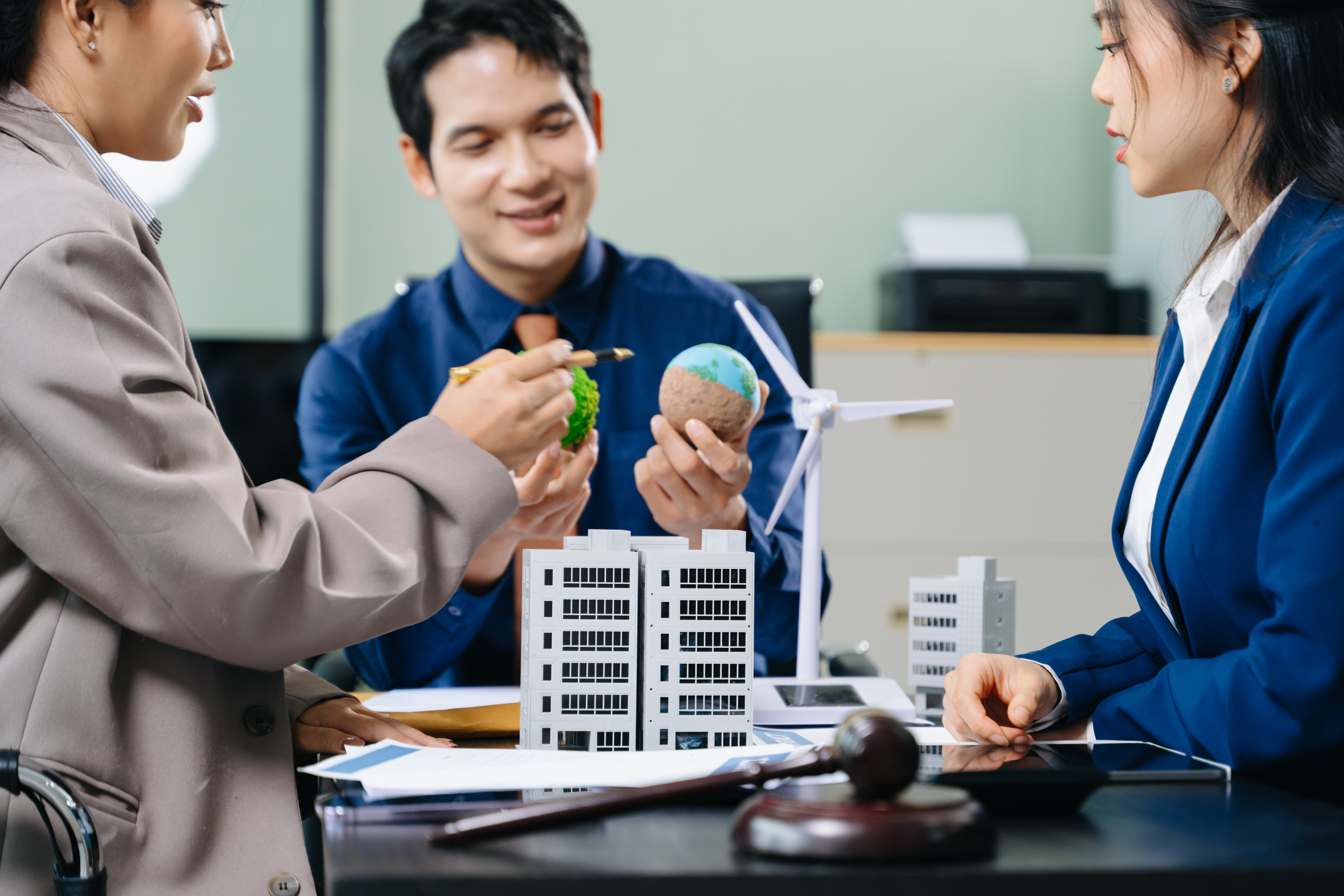 man standing beside another sitting man using computer