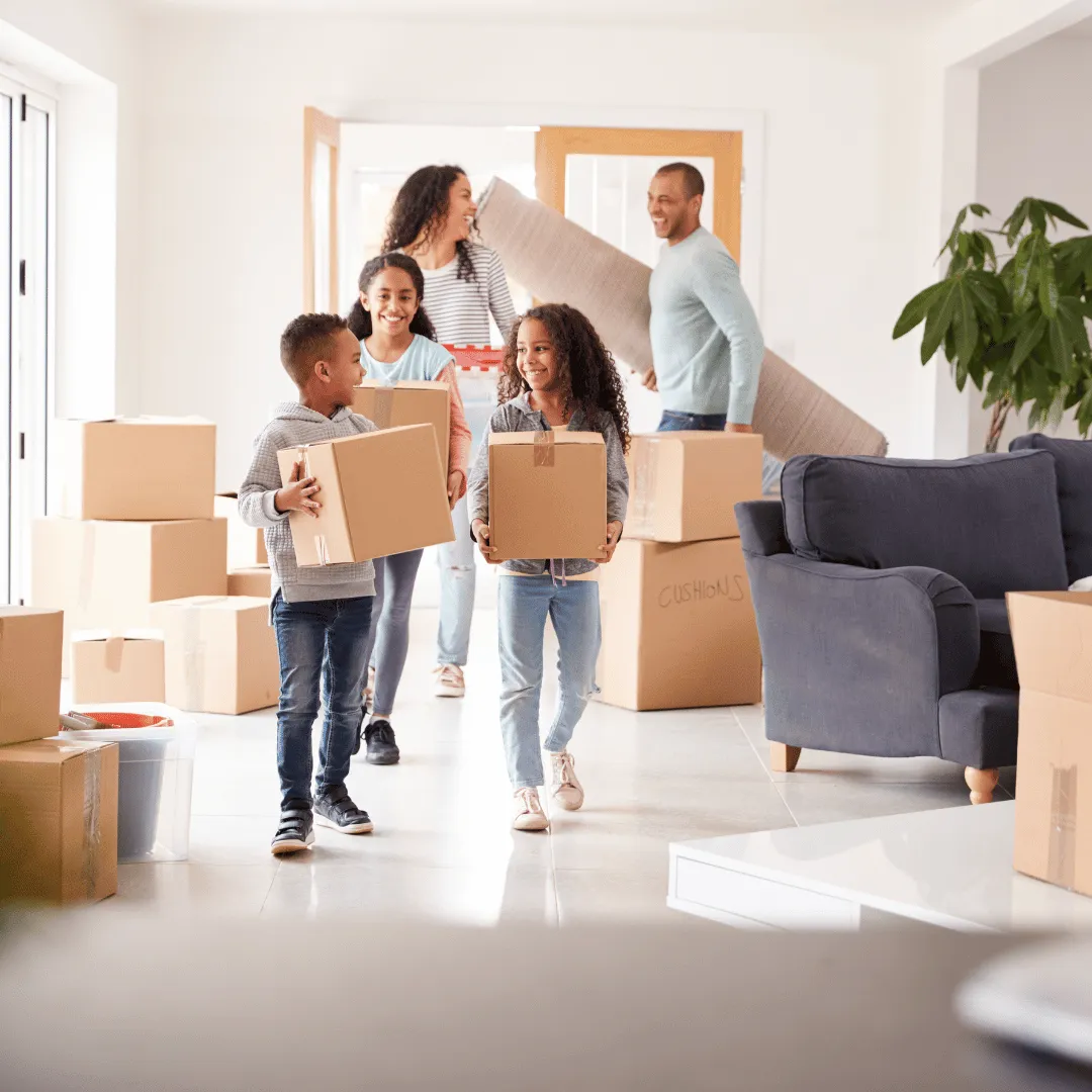  Happy family moving into a new home after mortgage approval, carrying boxes together in a bright living room.
