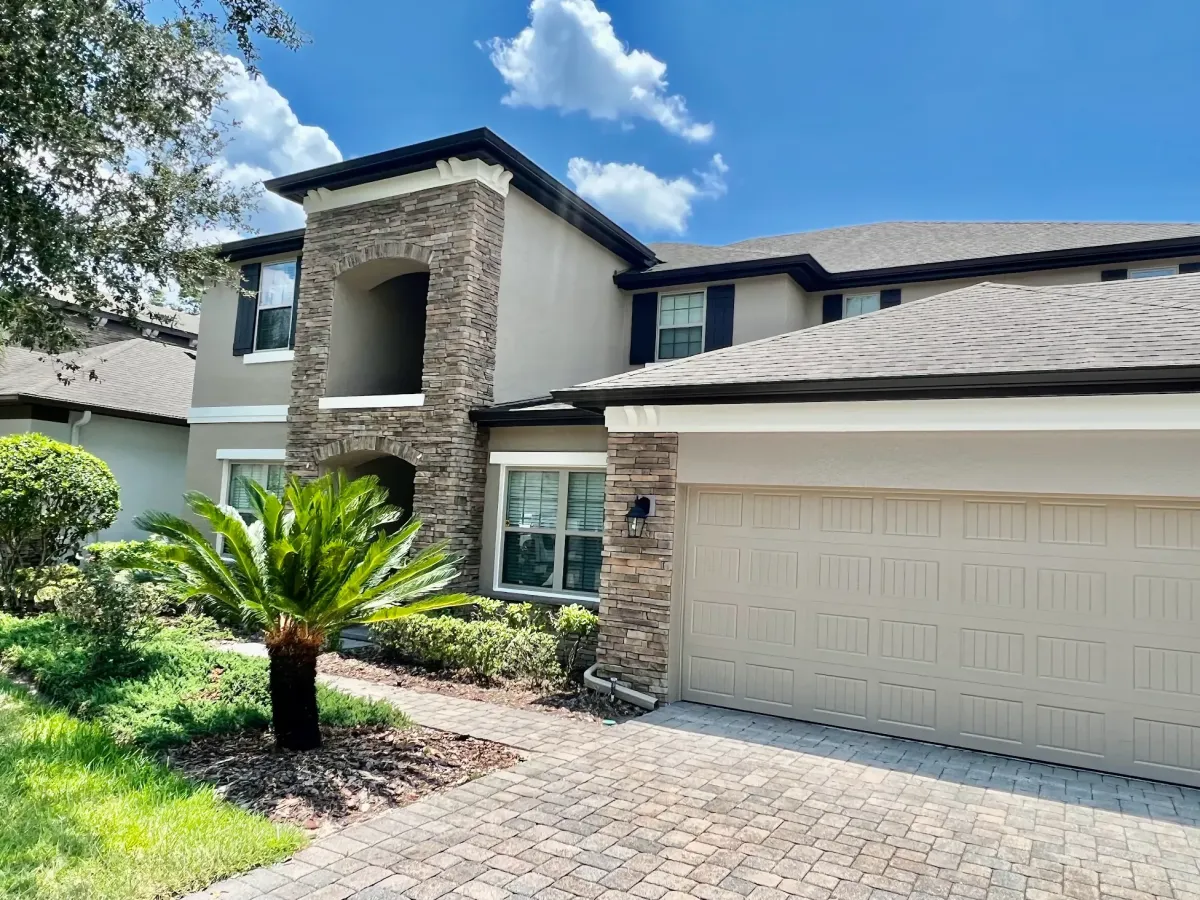 A luxury house painted by pro painter services in natural cream colors with dark brown accents.