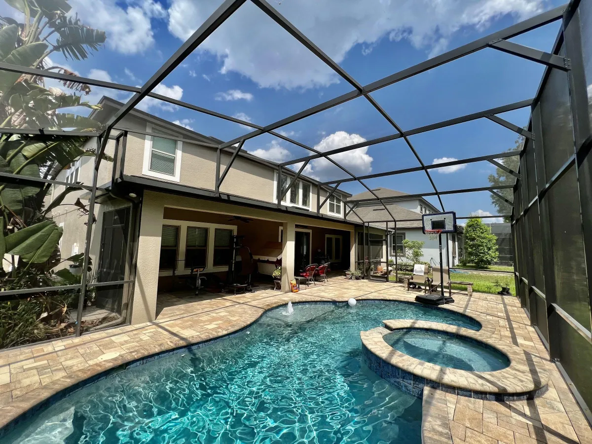 The back of a two story house painted by pro painting services featuring a spa pool.