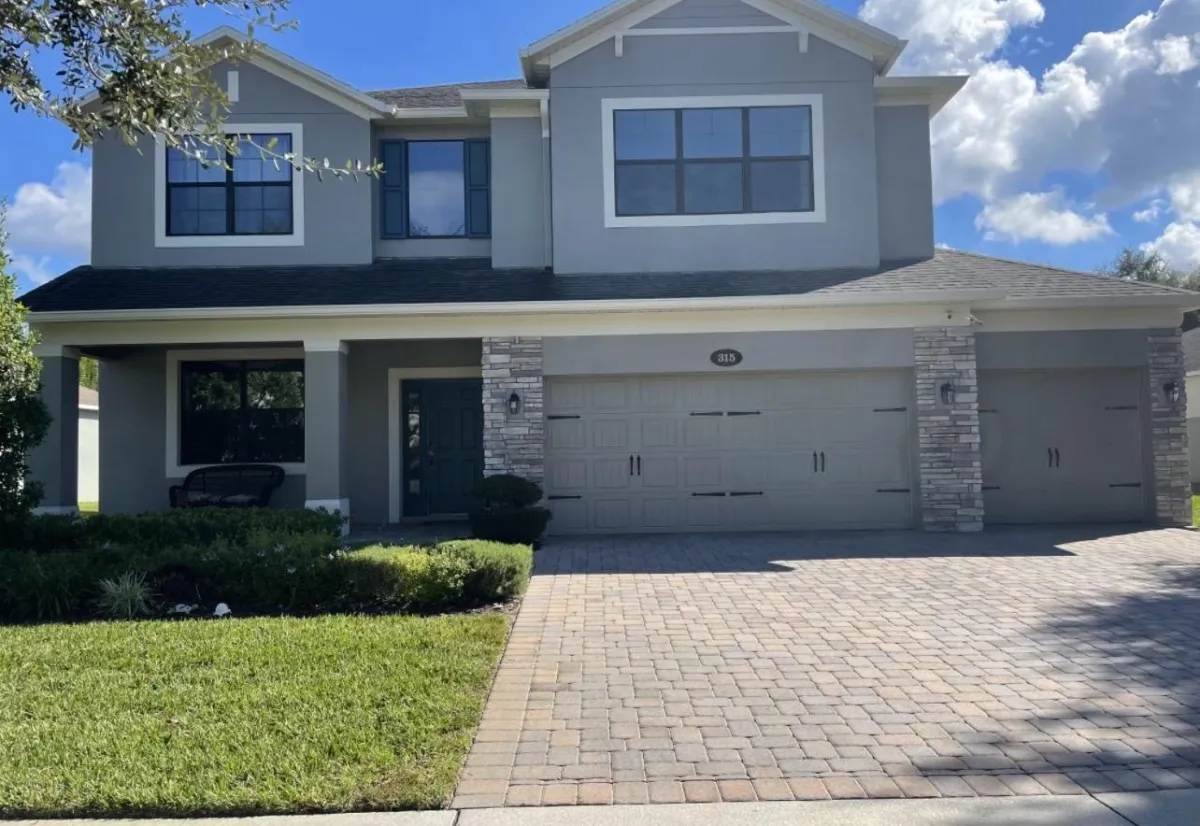 Front view of a two story house painted grey with white accents by pro painting services.