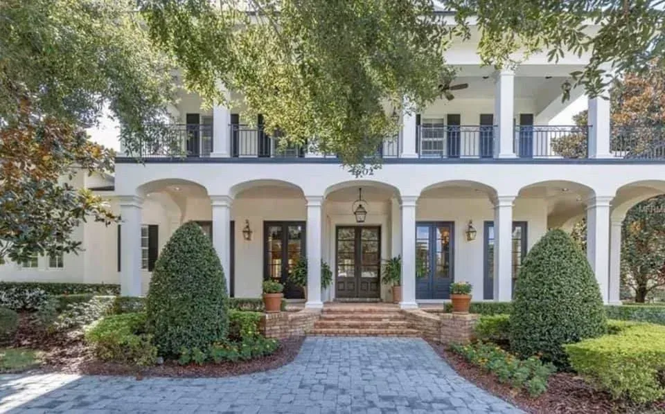 A house large estate painted white with dark accents by pro painting services.