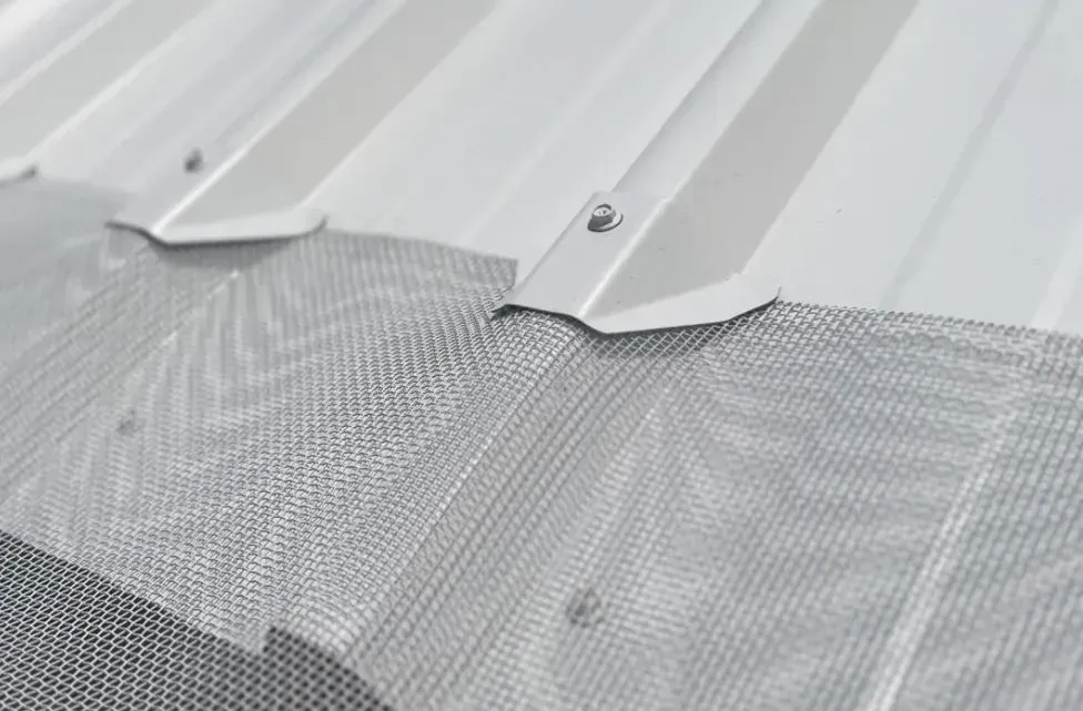 Close-up of aluminium gutter guard mesh on a corrugated roof