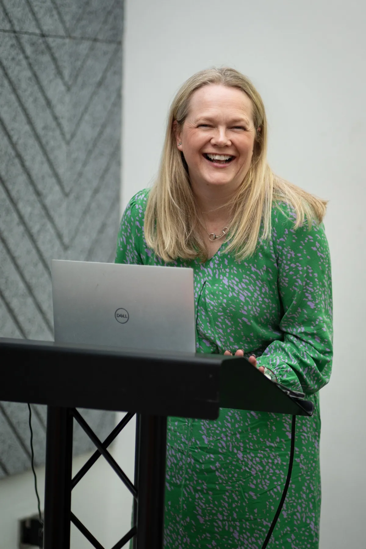 Sara McCracken FCIPR MBA PR training and consultant. Sara is wearing a green dress, is smiling and is in front of a laptop