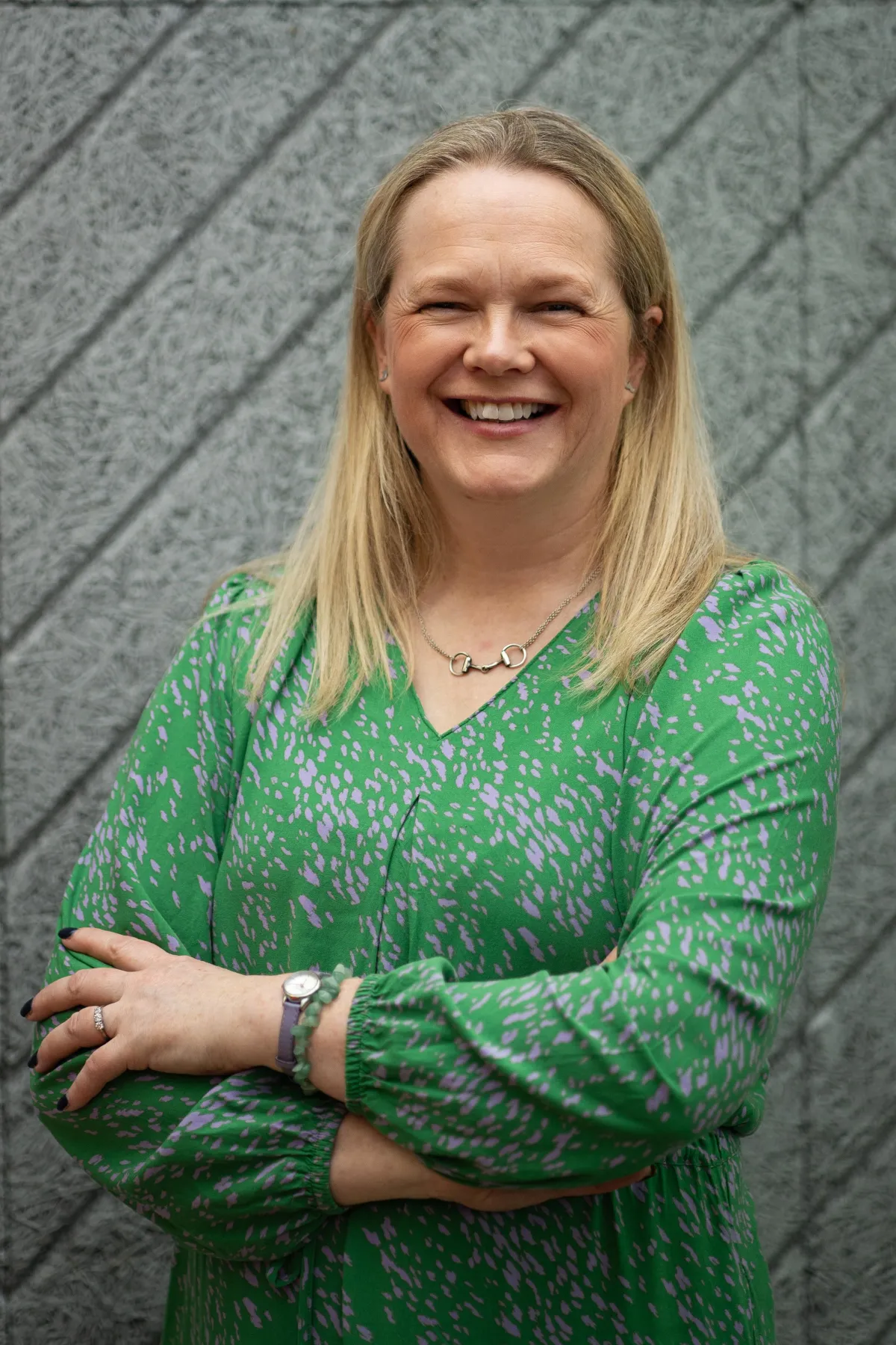 Sara McCracken FCIPR MBA PR training and consultant. Sara is wearing an orange blouse, is smiling and has her arms crossed