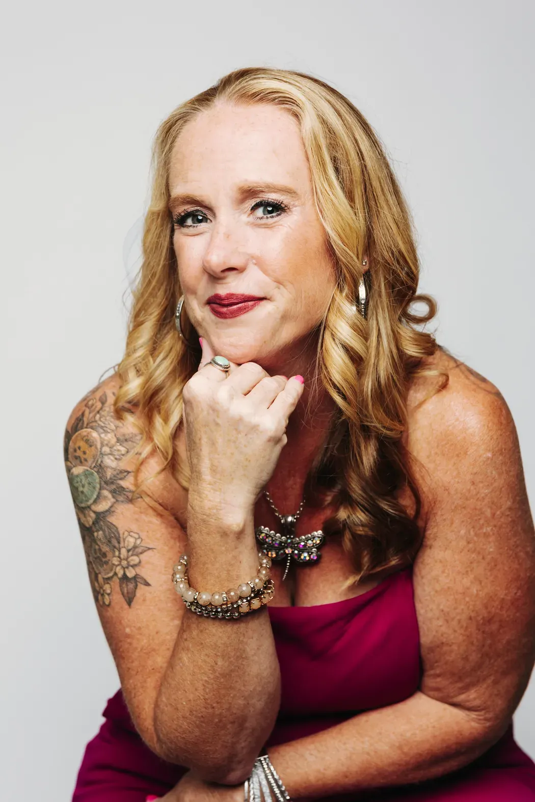Becca Powers® in a pink dress, chin resting on her hand, for the Radiant Values Assessment