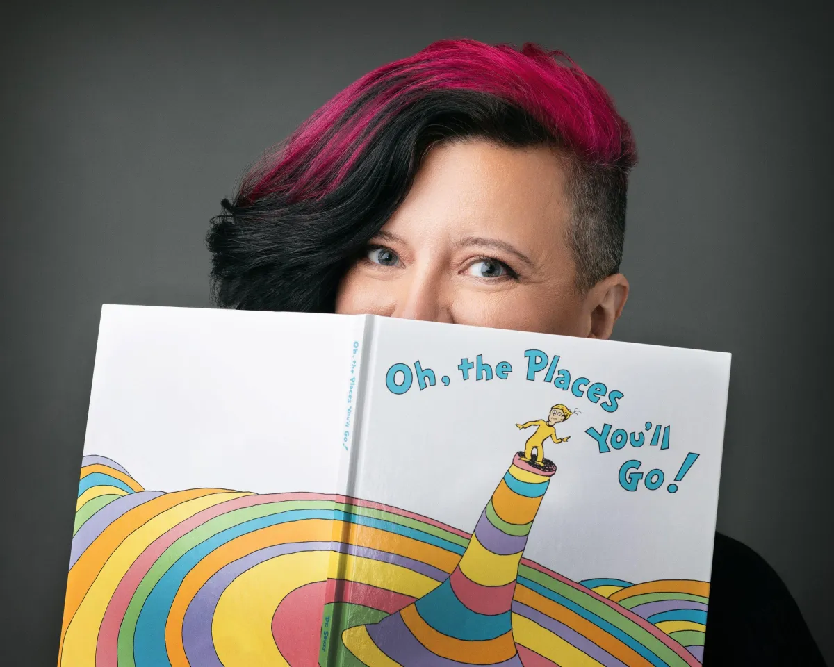 Vanessa Cardenas, Betrayal Recovery Specialist, holding Dr. Seuss' book 'Oh, the Places You'll Go!' on the homepage, inspiring visitors to embark on their journey of healing and personal growth.