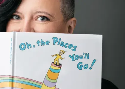 Vanessa Cardenas holding a book in her Westchester County office, representing the supportive and inspiring approach of her relationship coaching services