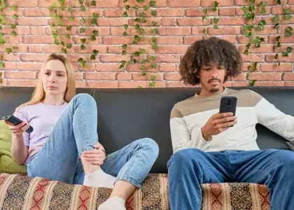 Couple sitting quietly together while experiencing emotional distance in their relationship