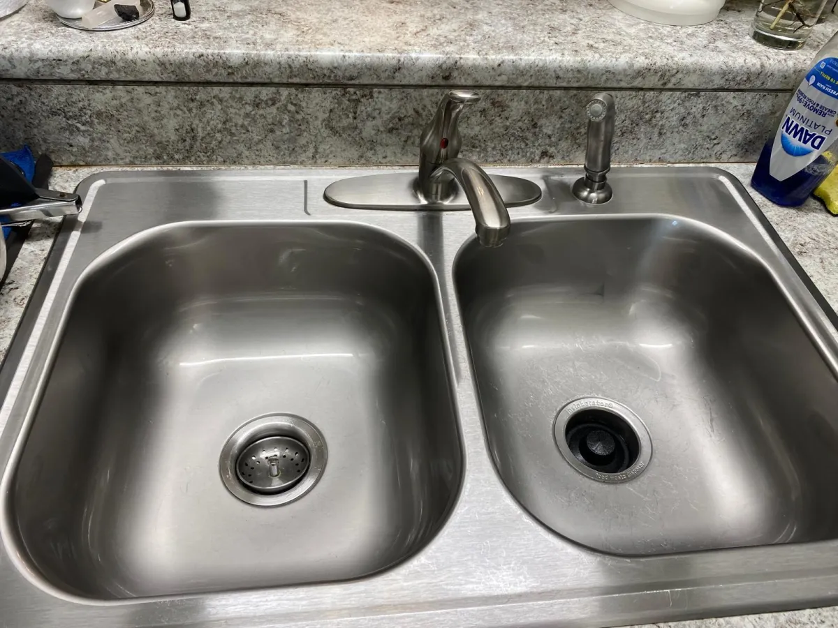 Close-up of a stainless steel kitchen sink with clean countertops in Jacksonville.