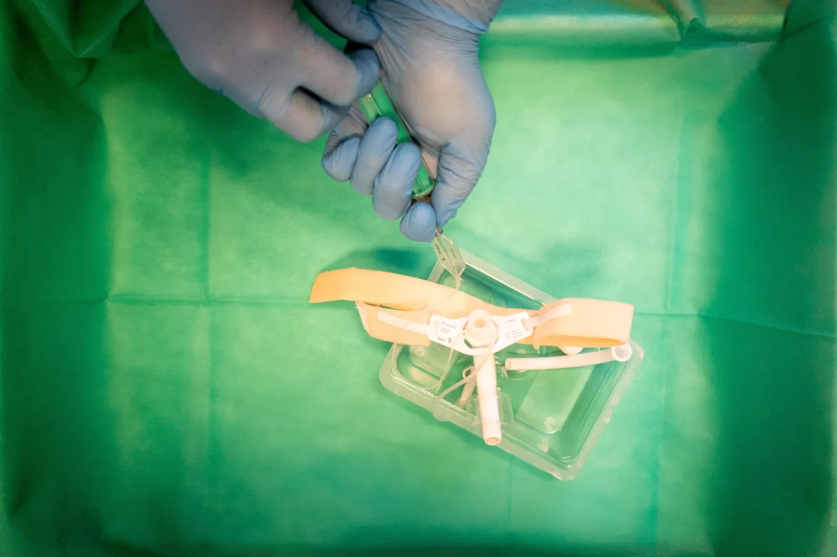 person in red sweater holding babys hand
