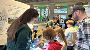 Family with children interacting with hands-on science exhibits