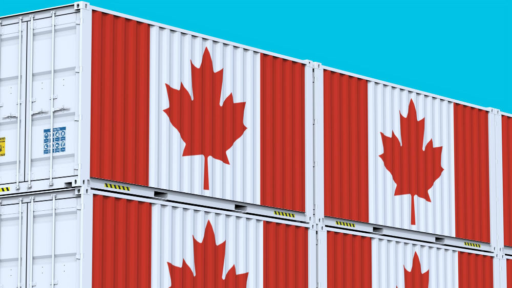 Stacked shipping containers painted with the Canadian flag, featuring red maple leaf symbols on white and red panels against a clear blue sky.