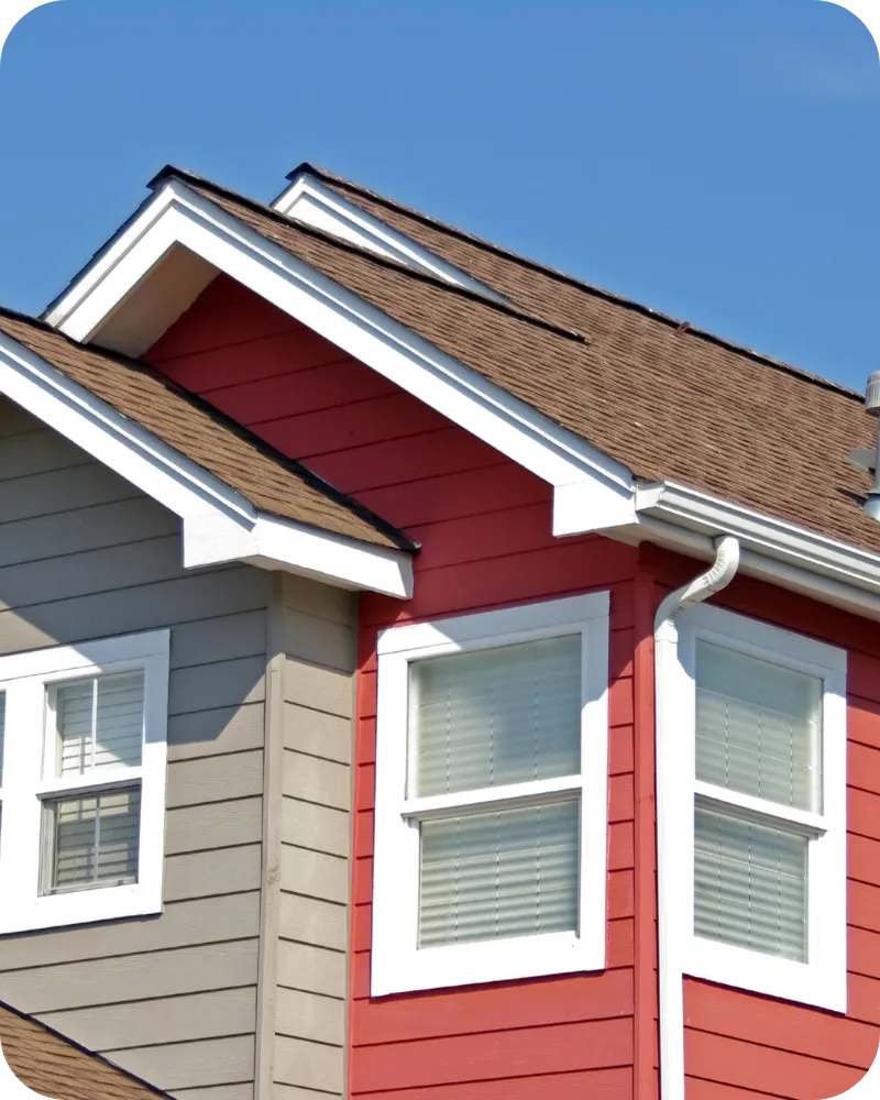 Red and gray Delaware home exterior under blue sky, highlighting roof and exterior areas for home inspection.