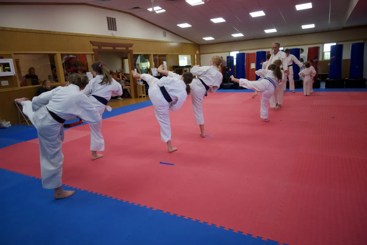 people in white uniform sitting on gray concrete road during daytime