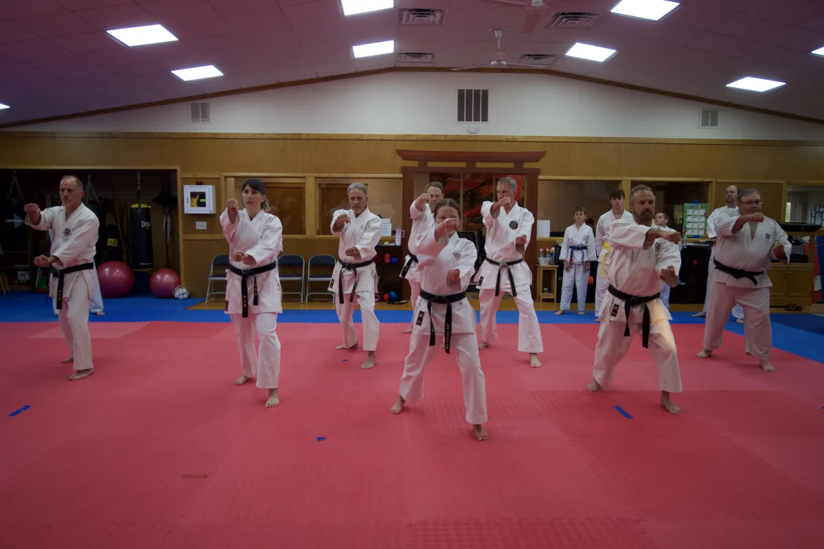 people in white uniform sitting on gray concrete road during daytime
