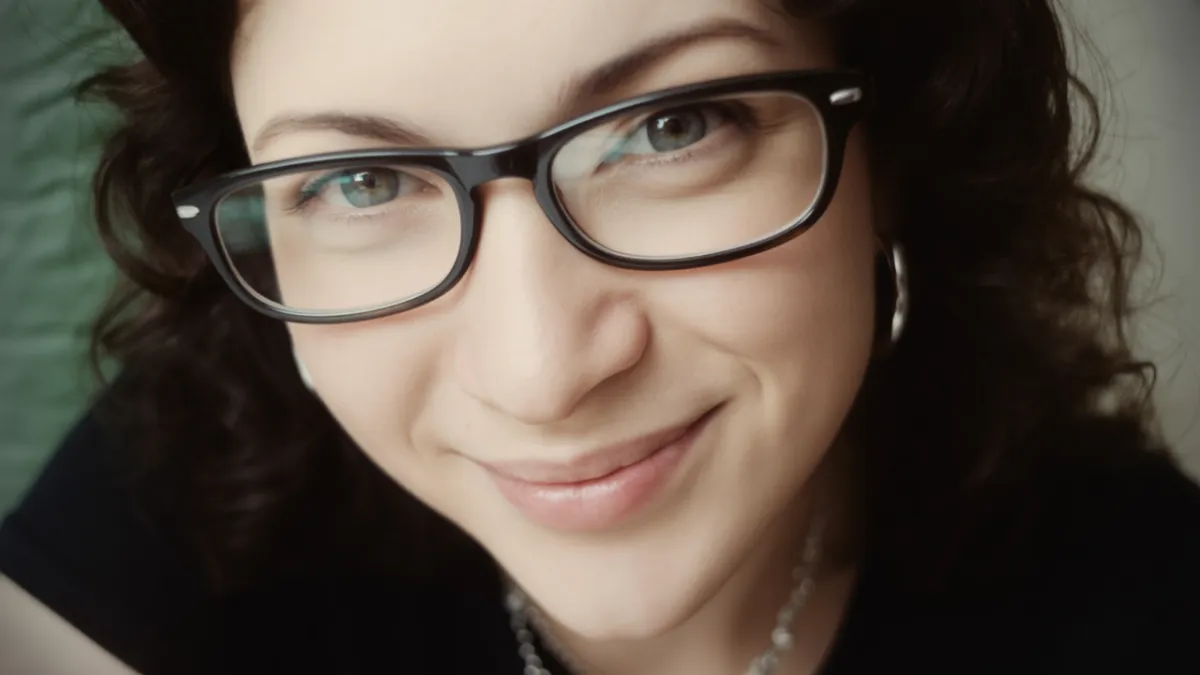 woman in white bathtub holding clear drinking glass