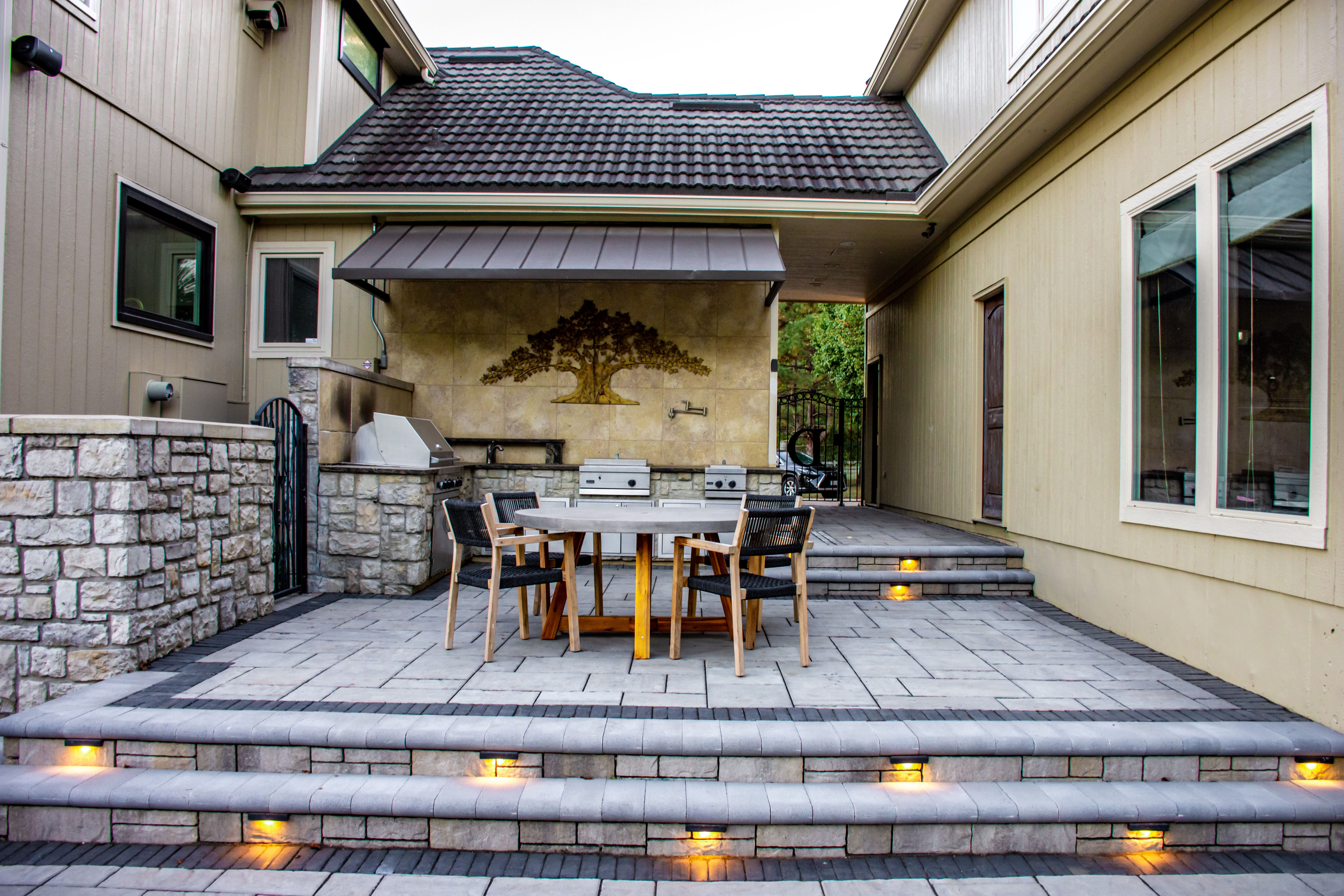 A tranquil garden with a reflective pond and brick pillars.