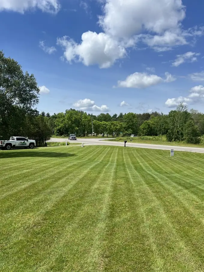Haul It Forward truck parked beside a freshly striped acreage lawn
