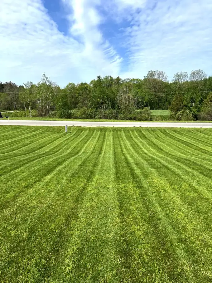 Freshly mowed lawn with crisp stripes on a large rural property in Oxford County
