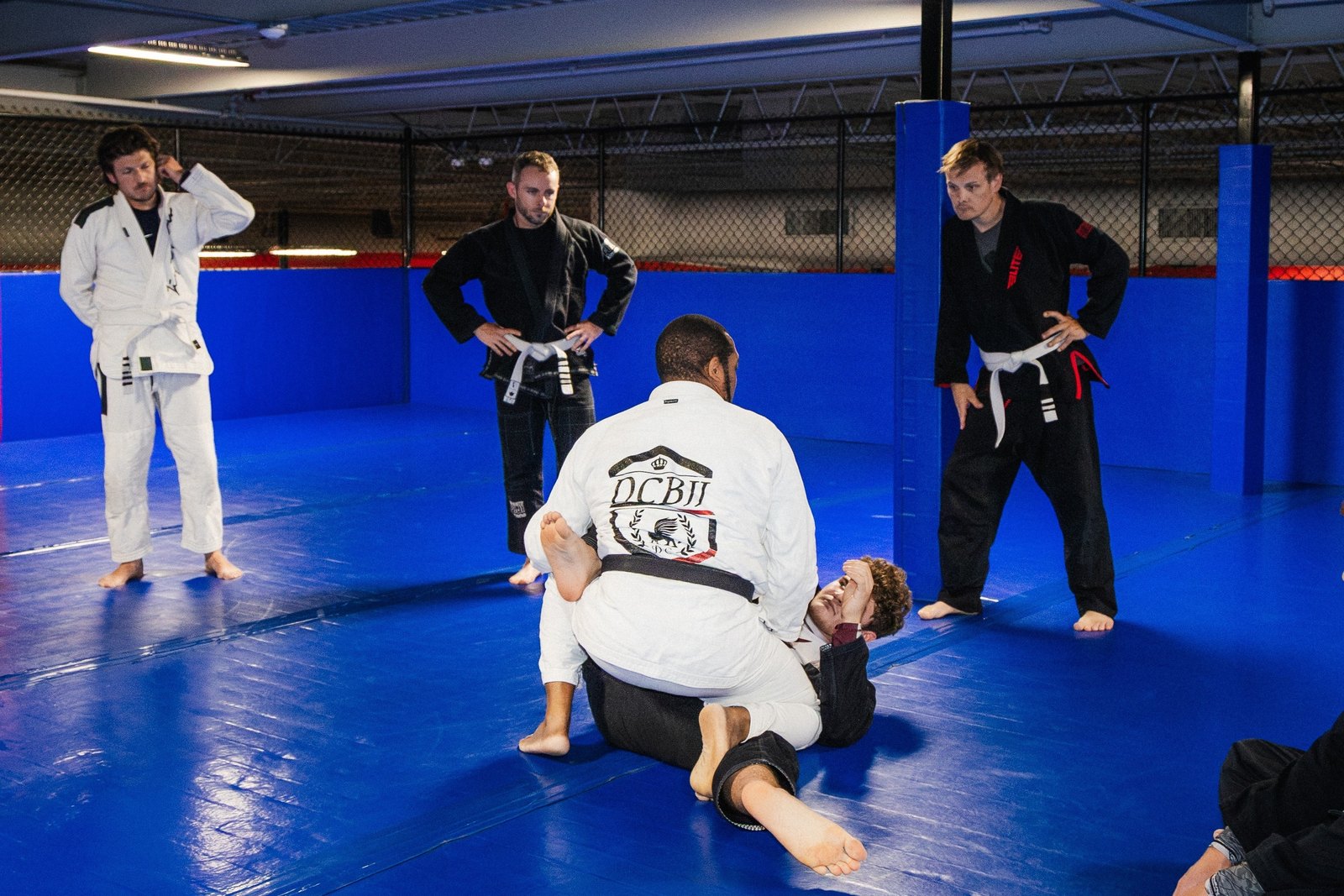 Black belt instructor David Close demonstrating a jiu-jitsu technique for students on the mat at X-Zen Sports
