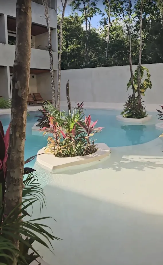 Tropical resort buildings along a sandy beach.