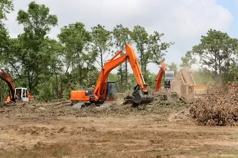 Heavy equipment performing land clearing and lot clearing project