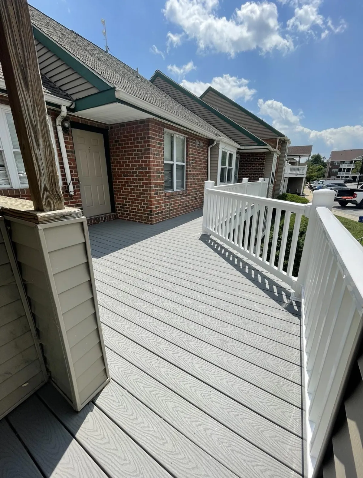 Gray composite decking with a white railing on a brick home | Prime Decks Delaware, serving New Castle County, DE