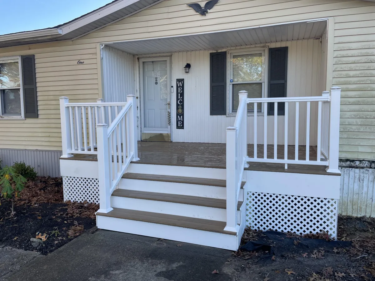 Front porch with white railings, tan composite steps and lattice skirting | Prime Decks Delaware, serving Elsmere, DE